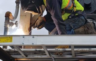 welder working on asphalt plant